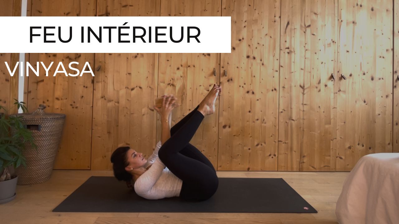 Marie effectuant un exercice de renforcement des abdominaux avec un accessoire pour une séance de vinyasa yoga sur le thème 'Feu intérieur'.